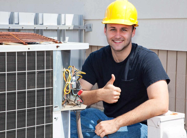 air conditioner repair near a worker with a yellow helmet